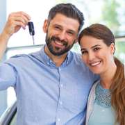 Smiling couple holding new car keys.